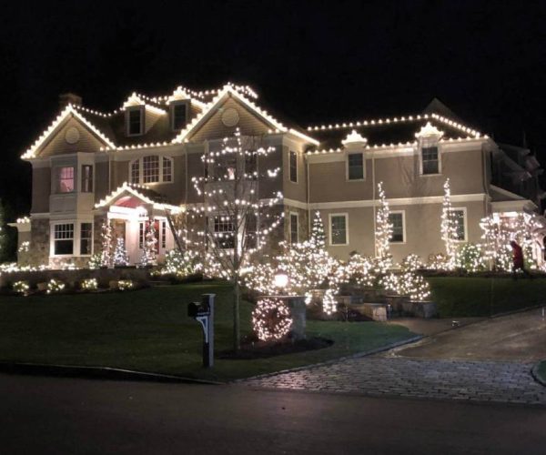 beige home with white holiday lights and decorations